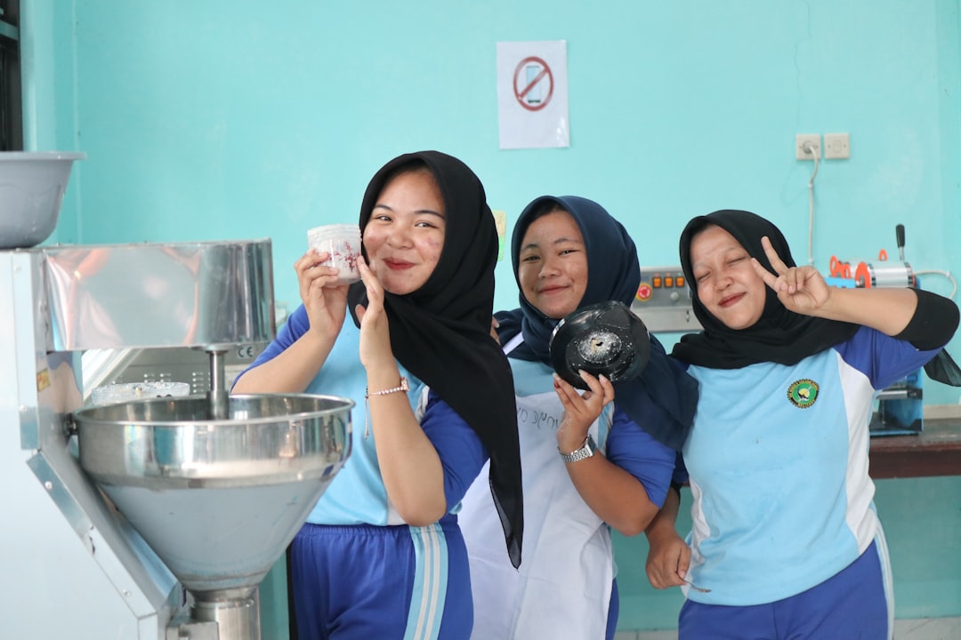 services-02 Three female students smile happily in the school kitchen